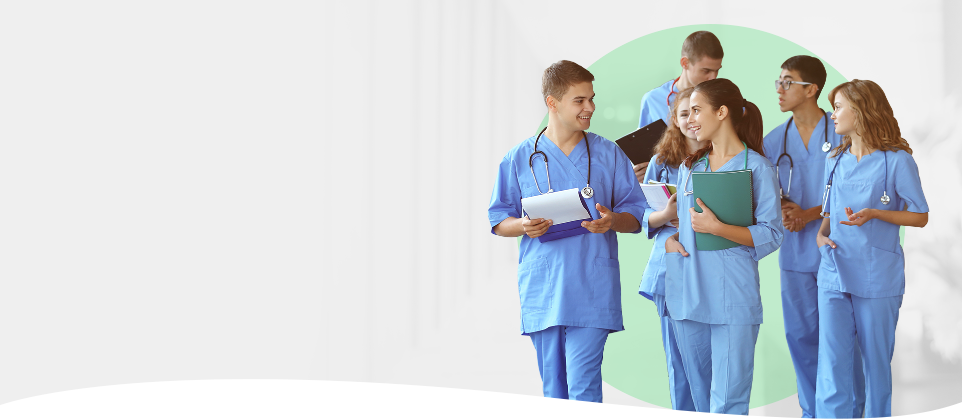 Medical students wearing scrubs discuss patient care in a hospital hallway, showcasing valuable vet resources.